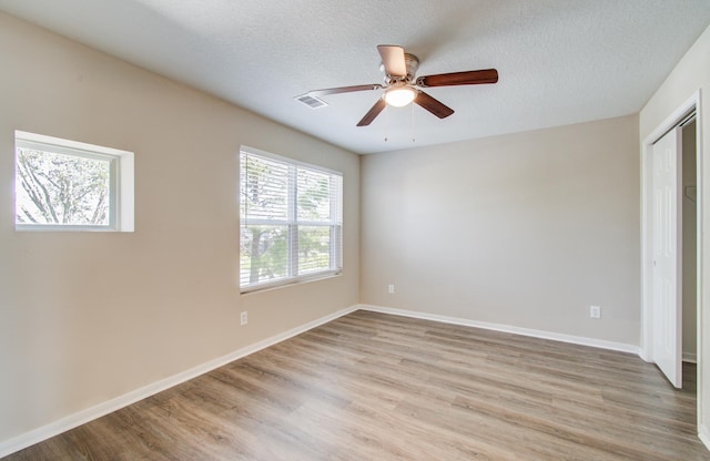 1211 Reedpoint Dr, Houston, TX 77090 - unfurnished bedroom featuring baseboards, light wood-type flooring, a textured ceiling, and visible vents
