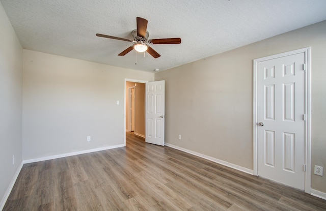 1211 Reedpoint Dr, Houston, TX 77090 - unfurnished bedroom with baseboards, a ceiling fan, a textured ceiling, and wood finished floors