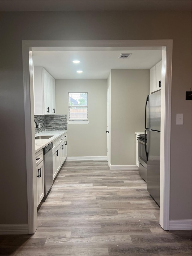 4409 Saint Goar St, Dickinson, TX 77539 - kitchen with appliances with stainless steel finishes, a sink, white cabinets, baseboards, and recessed lighting