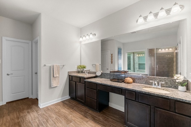 full bath with visible vents, a sink, baseboards, and wood finished floors