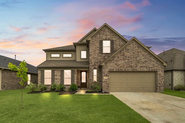 traditional home with roof with shingles, brick siding, a garage, a yard, and driveway