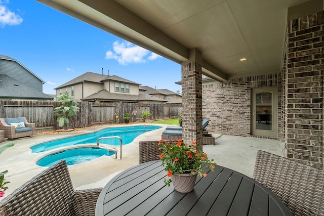 view of swimming pool with an in ground hot tub, a fenced in pool, a fenced backyard, and a patio area