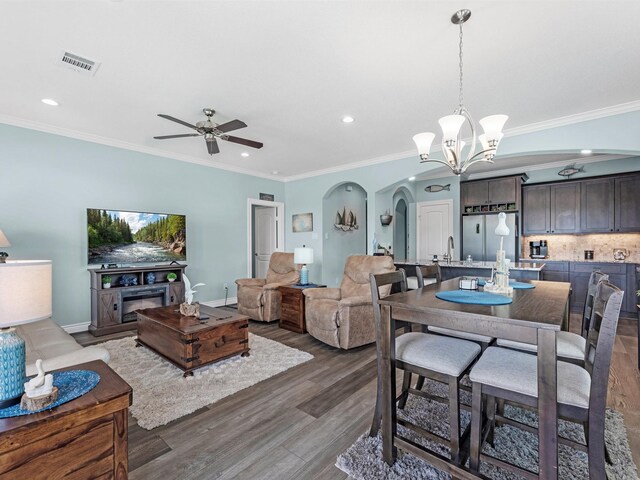 dining room with crown molding, arched walkways, recessed lighting, and ceiling fan with notable chandelier