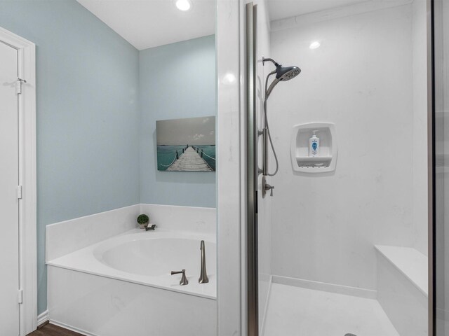 bathroom featuring a garden tub and a shower stall