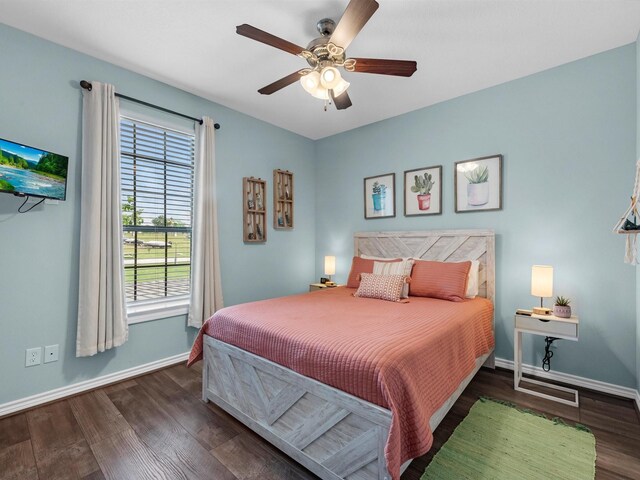 bedroom featuring ceiling fan, baseboards, multiple windows, and wood finished floors