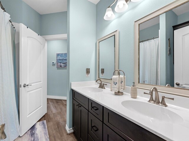 bathroom featuring double vanity, a sink, and wood finished floors