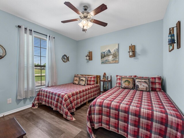 bedroom with baseboards, ceiling fan, and wood finished floors