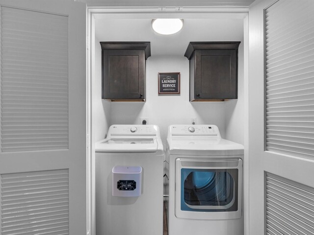 clothes washing area featuring cabinet space and washing machine and dryer