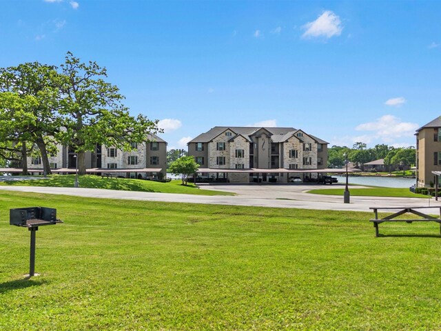 view of community with a lawn, parking, and a residential view
