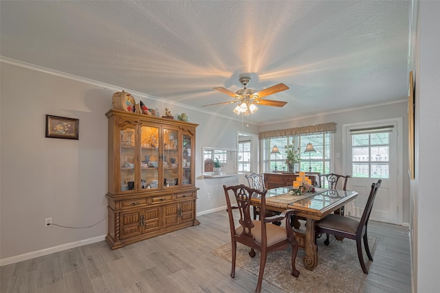 dining room featuring crown molding, ceiling fan, baseboards, and a healthy amount of sunlight