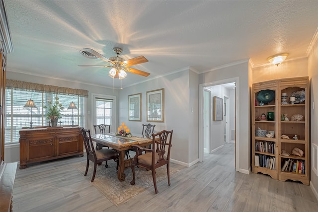 dining space with light wood-type flooring, a ceiling fan, a textured ceiling, and baseboards