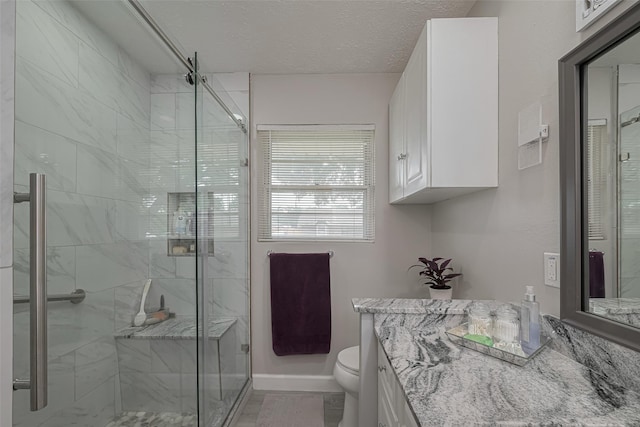 full bathroom featuring vanity, a marble finish shower, and toilet