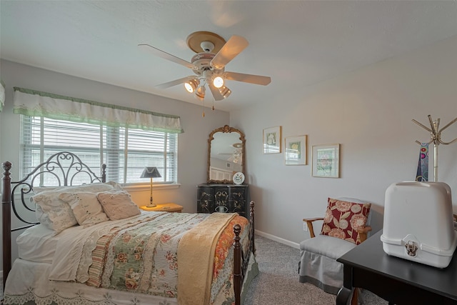 carpeted bedroom featuring baseboards, multiple windows, and ceiling fan
