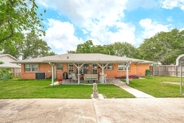 back of property with brick siding, fence, a yard, and cooling unit
