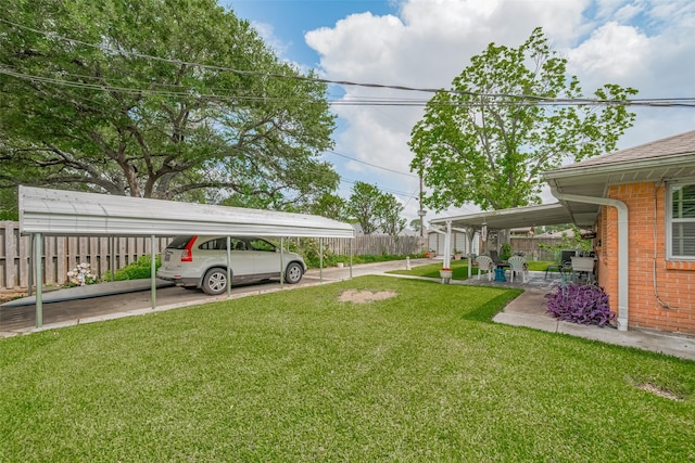 view of yard featuring fence and a carport