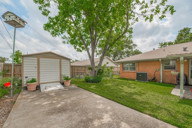 view of yard featuring central AC unit, a fenced backyard, and a patio area