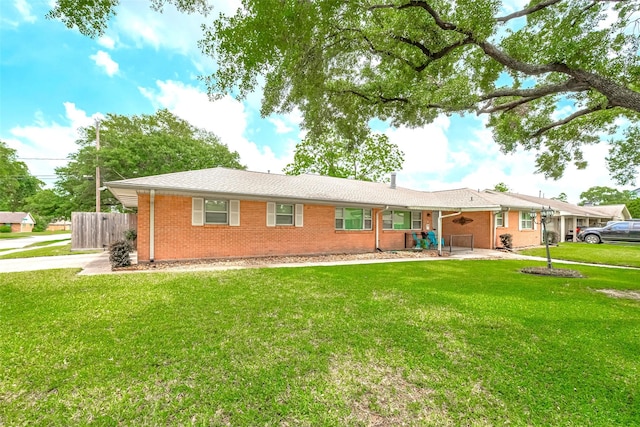 view of front of house with brick siding, fence, and a front yard