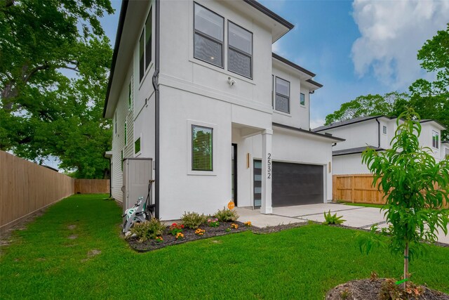 view of front of home featuring fence, stucco siding, an attached garage, and driveway