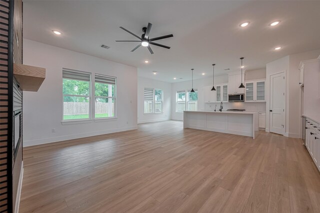 unfurnished living room with visible vents, a fireplace, baseboards, ceiling fan, and recessed lighting