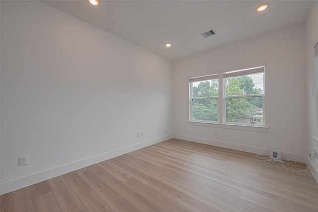empty room featuring baseboards, recessed lighting, light wood-style flooring, and visible vents