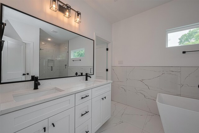 full bathroom featuring tile walls, a marble finish shower, a sink, and marble finish floor