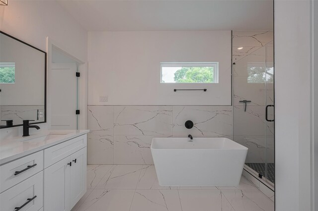 full bath featuring tile walls, a healthy amount of sunlight, and marble finish floor
