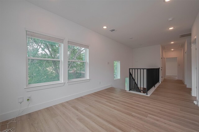 empty room with visible vents, recessed lighting, baseboards, and light wood-type flooring