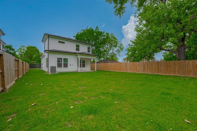 back of house with a lawn, a fenced backyard, and central air condition unit