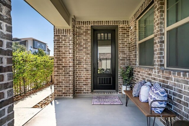 property entrance featuring brick siding