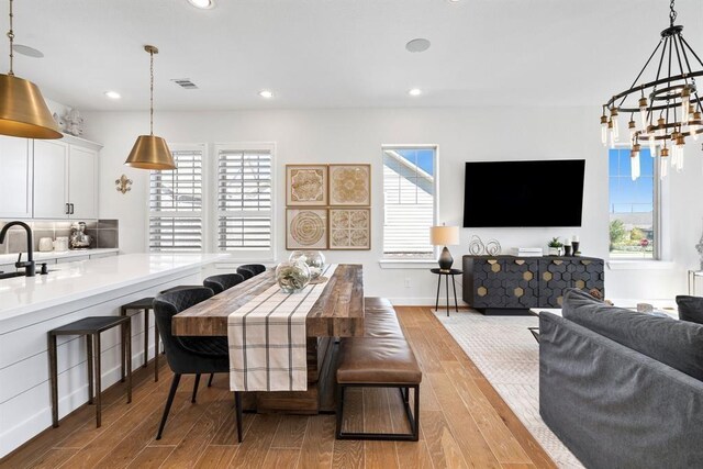 dining area featuring recessed lighting, wood finished floors, a chandelier, and visible vents