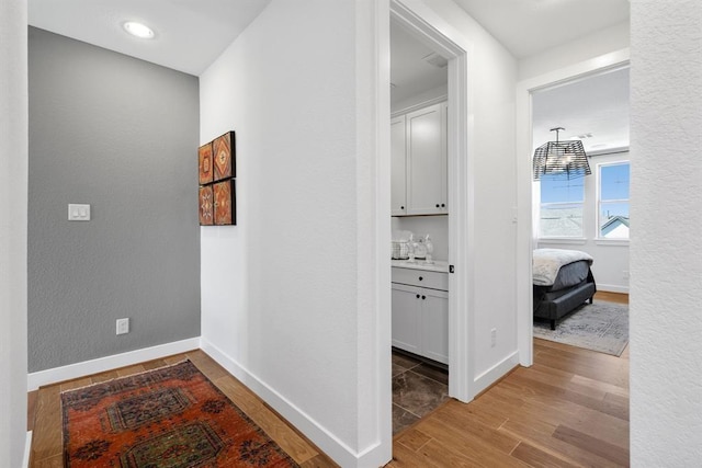 hallway featuring baseboards and wood finished floors