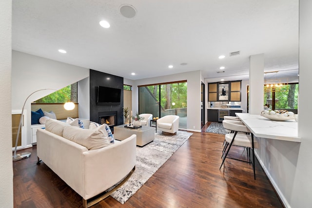living room with healthy amount of natural light, a fireplace, dark wood-type flooring, recessed lighting, and baseboards