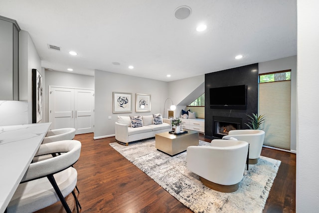living area with dark wood-type flooring, recessed lighting, a fireplace, and baseboards