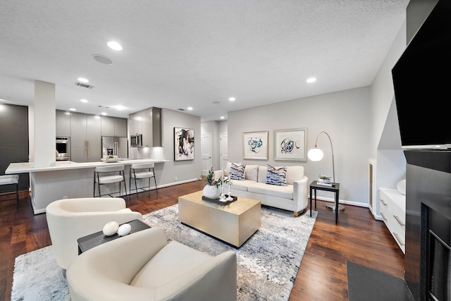 living room featuring baseboards, dark wood-style floors, and recessed lighting