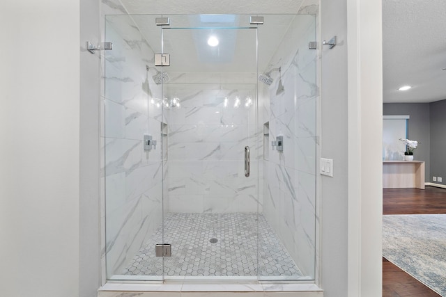 bathroom with wood finished floors, a marble finish shower, and recessed lighting