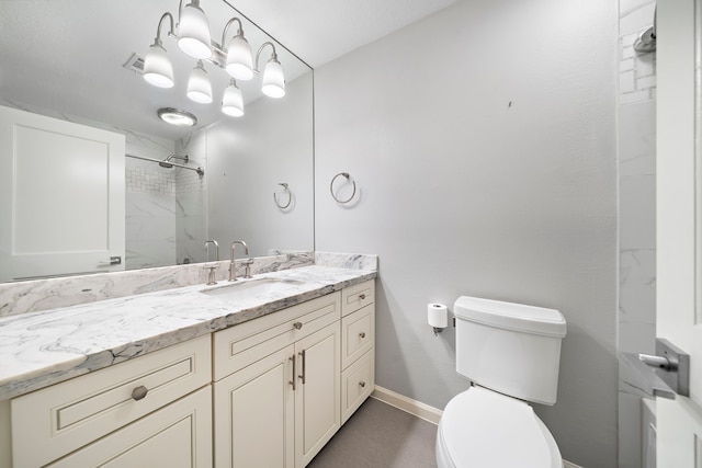 bathroom featuring toilet, a shower, baseboards, and vanity