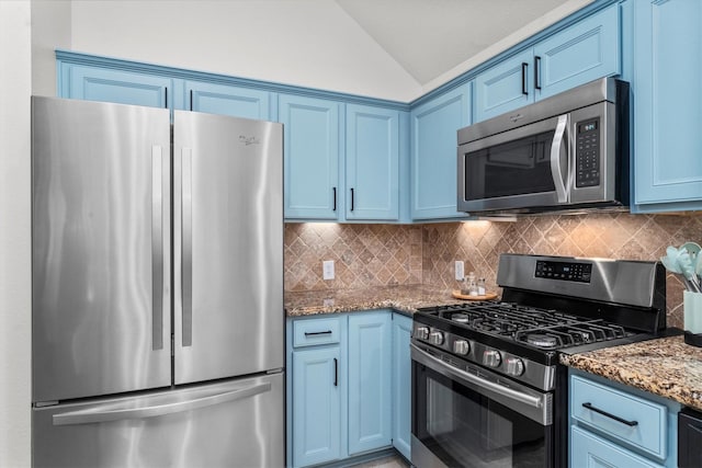 kitchen with light stone countertops, appliances with stainless steel finishes, blue cabinetry, decorative backsplash, and lofted ceiling