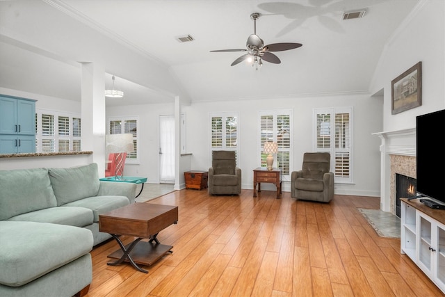living area with a ceiling fan, visible vents, a high end fireplace, vaulted ceiling, and ornamental molding