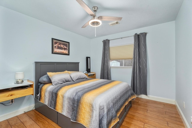 bedroom with a ceiling fan, baseboards, visible vents, and light wood-style floors