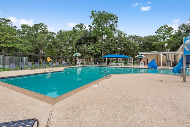 community pool with a patio and fence