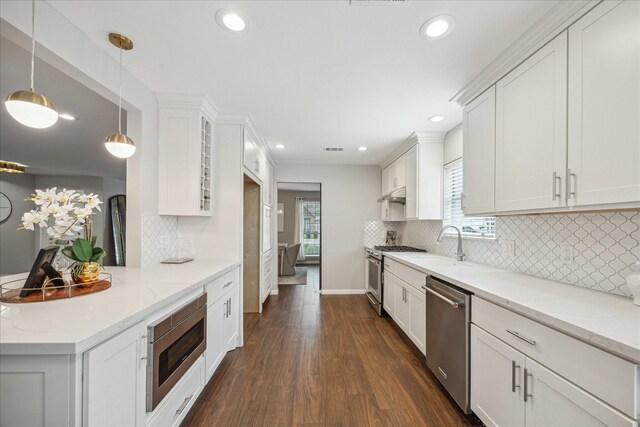 kitchen with decorative backsplash, dark wood-style flooring, light stone counters, stainless steel appliances, and white cabinetry