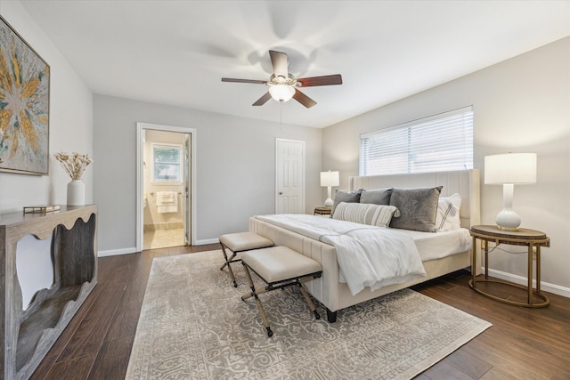 bedroom with baseboards, ceiling fan, ensuite bath, and dark wood-style floors