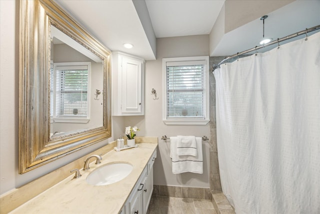 bathroom with baseboards, plenty of natural light, vanity, and curtained shower