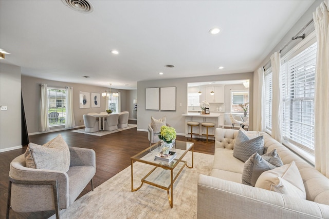 living room with dark wood-style flooring, recessed lighting, baseboards, and a chandelier