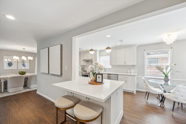 kitchen with baseboards, dark wood-style flooring, backsplash, and a notable chandelier