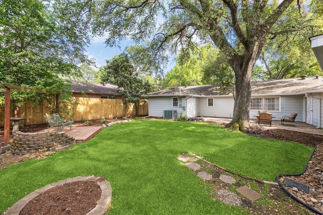 view of yard with central air condition unit, a deck, fence, and a patio area