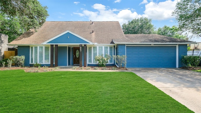 view of front of home featuring roof with shingles, a front lawn, a garage, stucco siding, and driveway