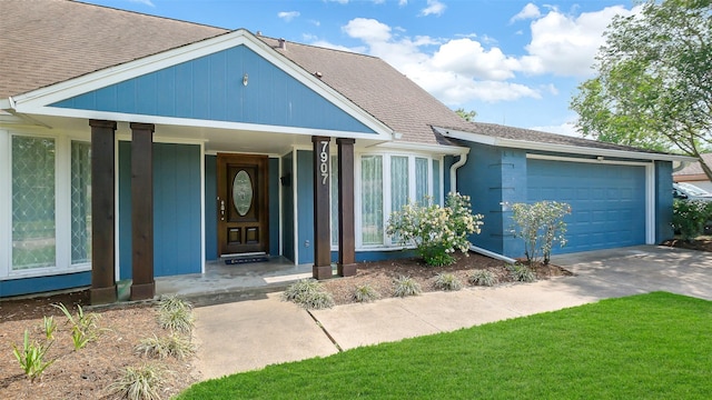 view of front of property featuring concrete driveway, a shingled roof, and a garage