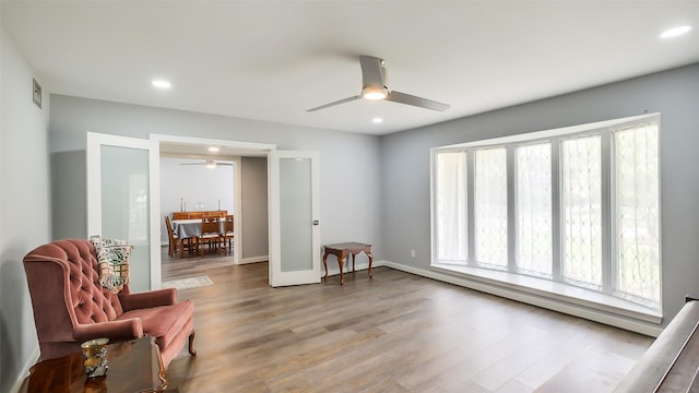 sitting room with a ceiling fan, baseboards, recessed lighting, and wood finished floors