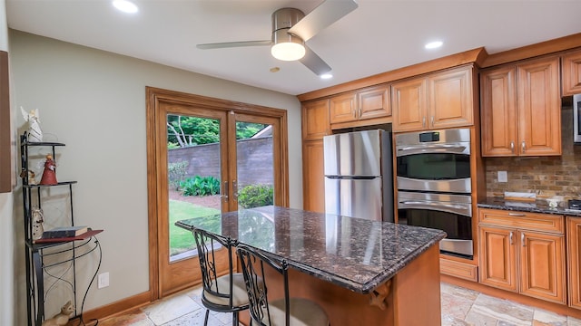 kitchen with ceiling fan, appliances with stainless steel finishes, french doors, dark stone countertops, and backsplash